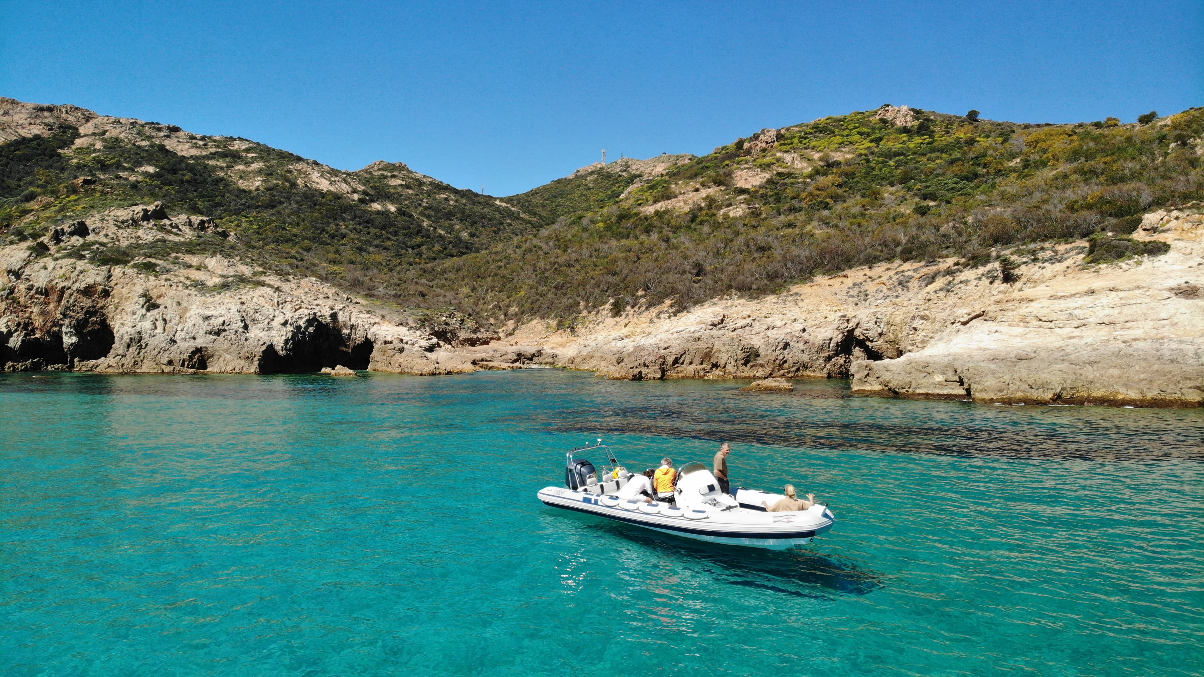 The Stella Tours boat anchored beside towering cliffs
