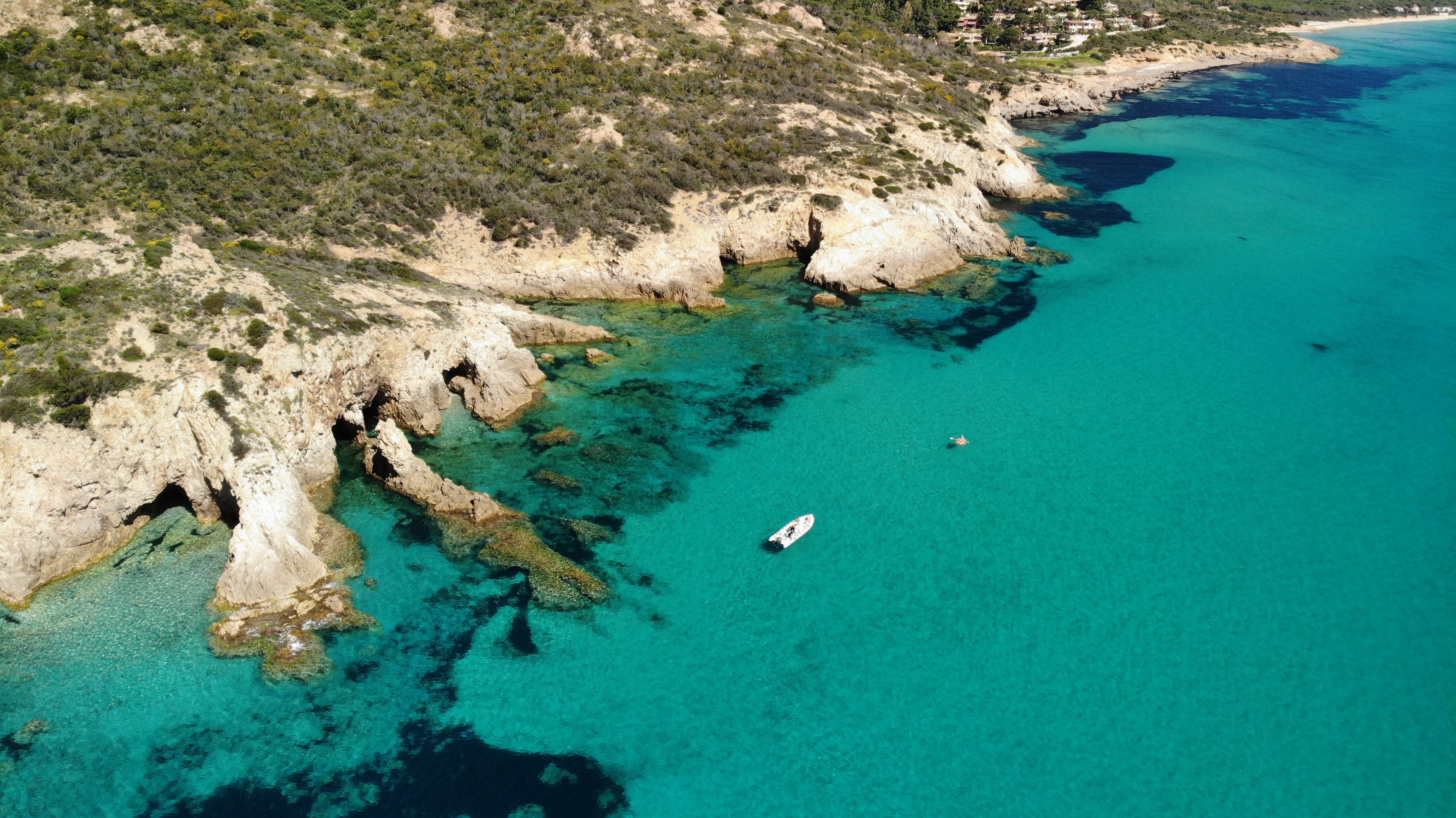 Aerial view of boat near Sardinian coast at golden hour sunset
